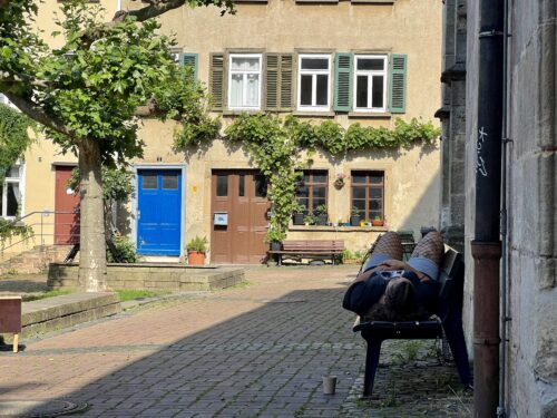 Junge Frau relaxed auf einer Bank in der Altstadt Tübingen